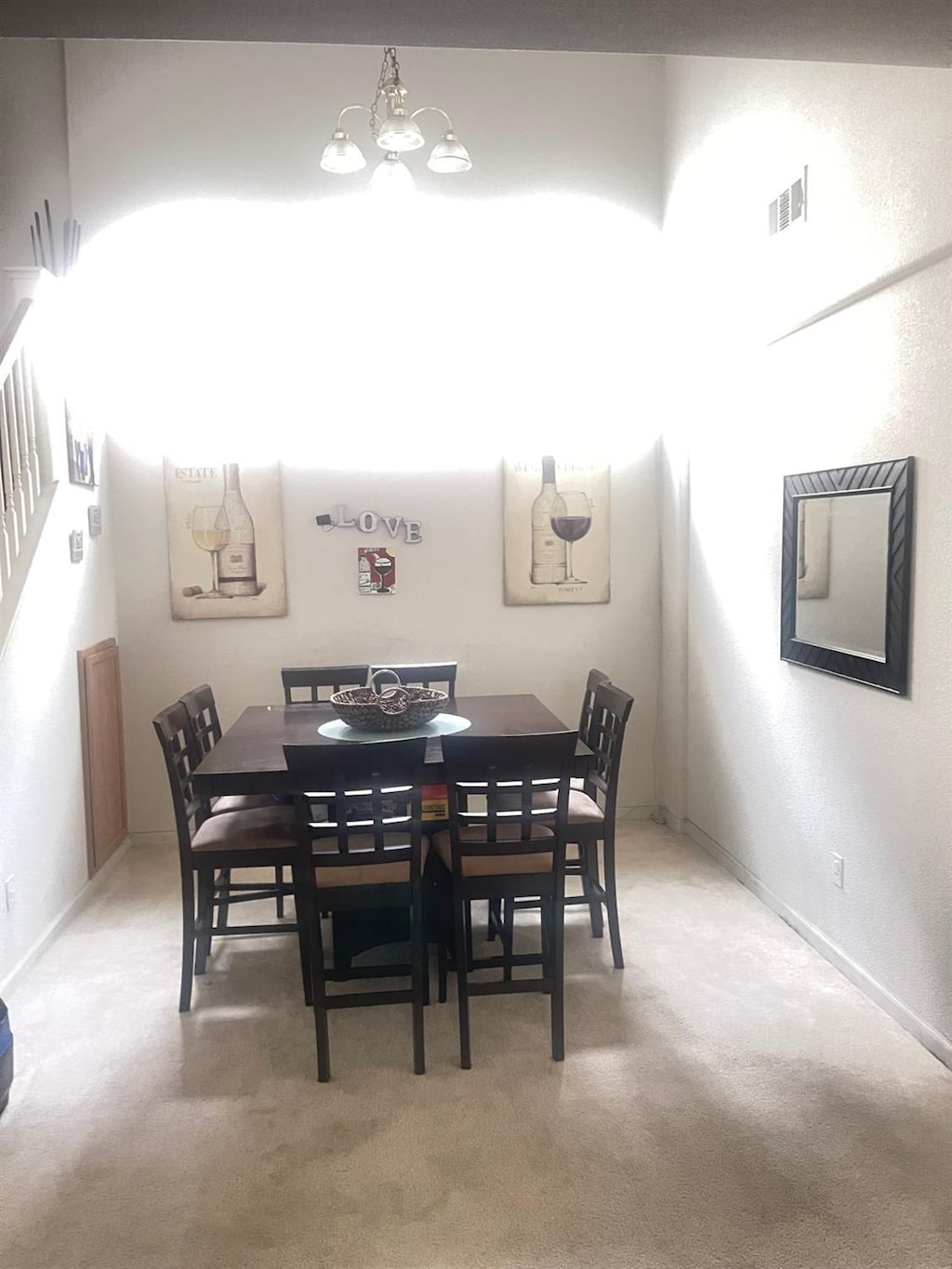 carpeted dining room featuring baseboards, visible vents, and a notable chandelier