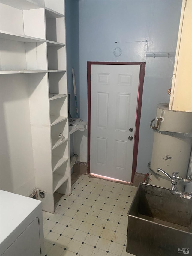 interior space with secured water heater, a sink, and tile patterned floors