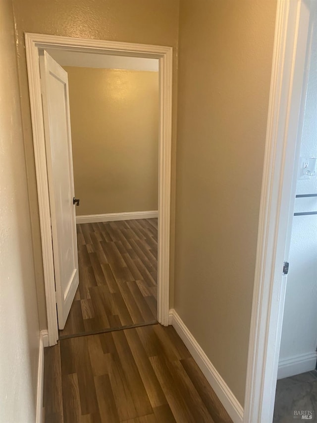 hall featuring baseboards and wood finished floors