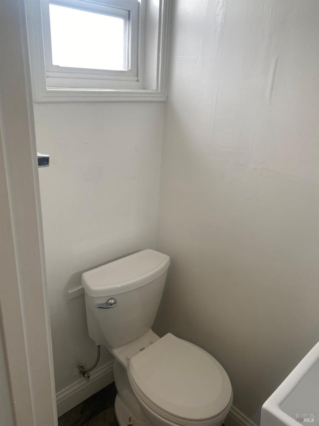 bathroom featuring toilet and baseboards