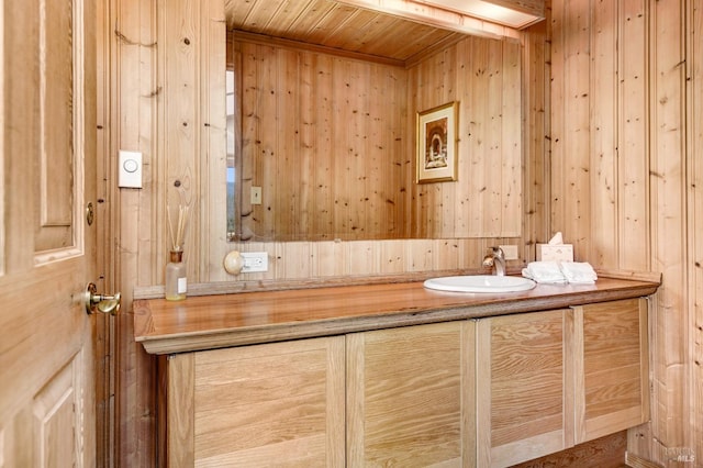 bathroom with wood walls, wood ceiling, and vanity