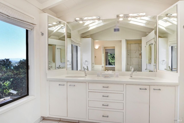 bathroom featuring double vanity, lofted ceiling with skylight, and a sink