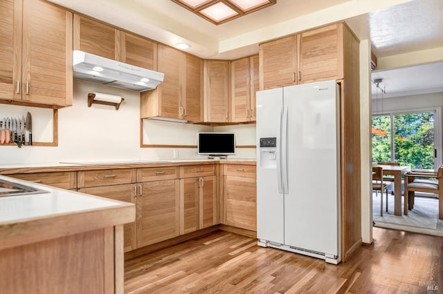 kitchen with light countertops, light brown cabinetry, white fridge with ice dispenser, light wood-type flooring, and under cabinet range hood