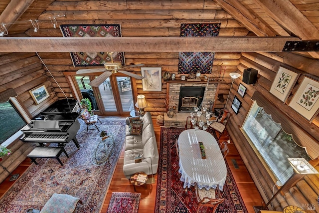 living area featuring visible vents, beamed ceiling, and wood finished floors