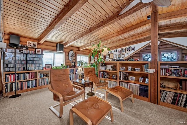 sitting room with carpet floors, wood ceiling, bookshelves, beam ceiling, and rustic walls