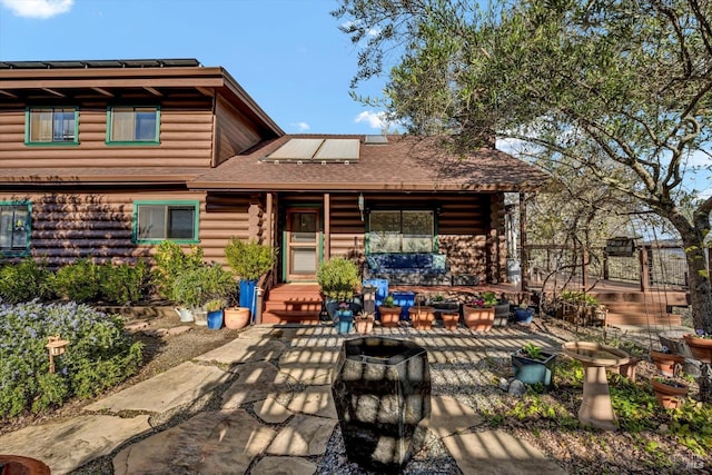 back of property with a patio, covered porch, a shingled roof, outdoor lounge area, and log siding