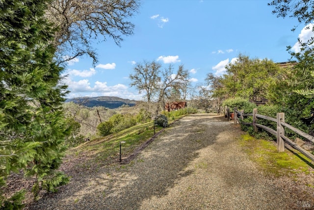 view of yard with fence and a rural view