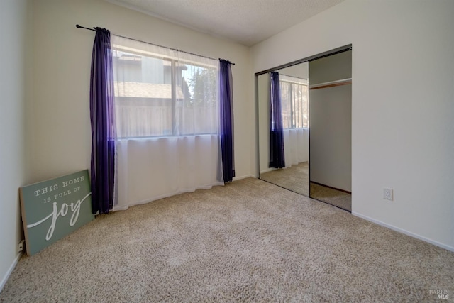 unfurnished bedroom with carpet, a textured ceiling, and a closet