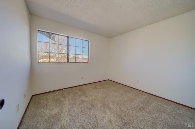 empty room featuring a textured ceiling, baseboards, and carpet flooring