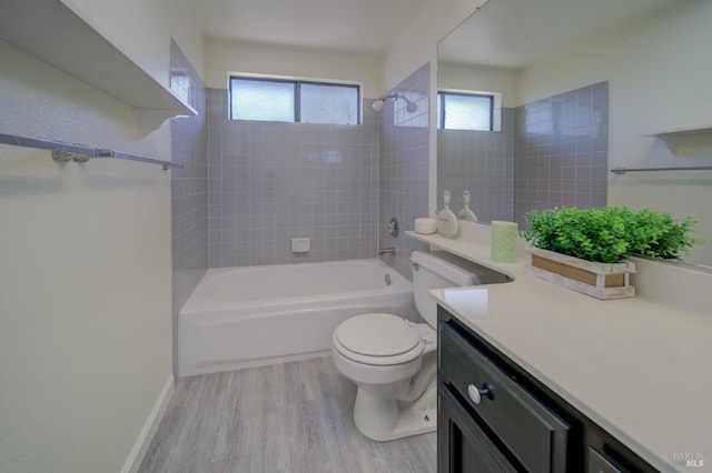 bathroom featuring shower / bathtub combination, toilet, wood finished floors, vanity, and baseboards