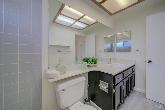 bathroom with wood finished floors, vanity, and toilet