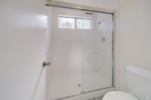 full bathroom featuring toilet and an enclosed shower