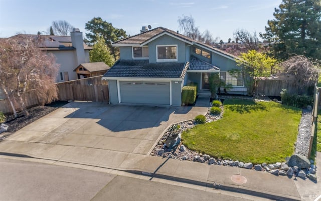 traditional-style home with an attached garage, fence, a tiled roof, concrete driveway, and a front lawn