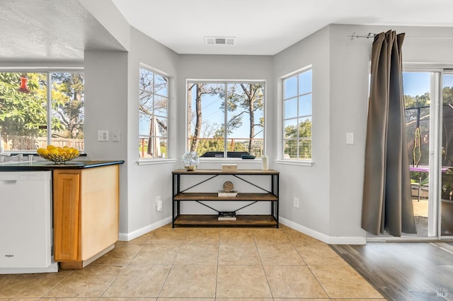 entryway with light tile patterned floors, baseboards, and visible vents