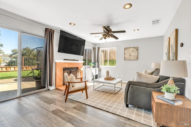 living room featuring visible vents, a tile fireplace, ceiling fan, wood finished floors, and recessed lighting