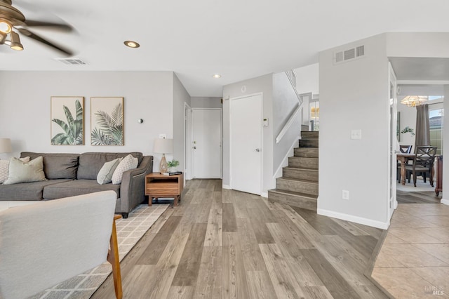 living room featuring recessed lighting, a ceiling fan, visible vents, stairs, and light wood finished floors