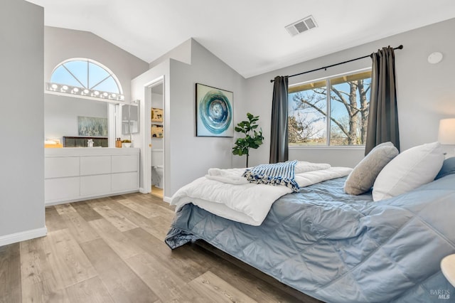 bedroom with light wood-type flooring, lofted ceiling, visible vents, and multiple windows