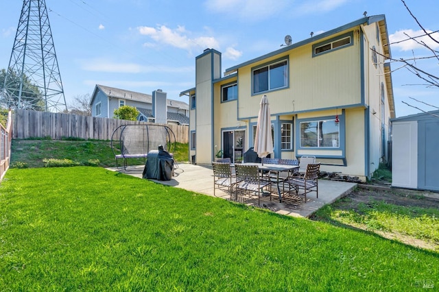 rear view of house featuring a storage shed, a yard, a patio area, and fence