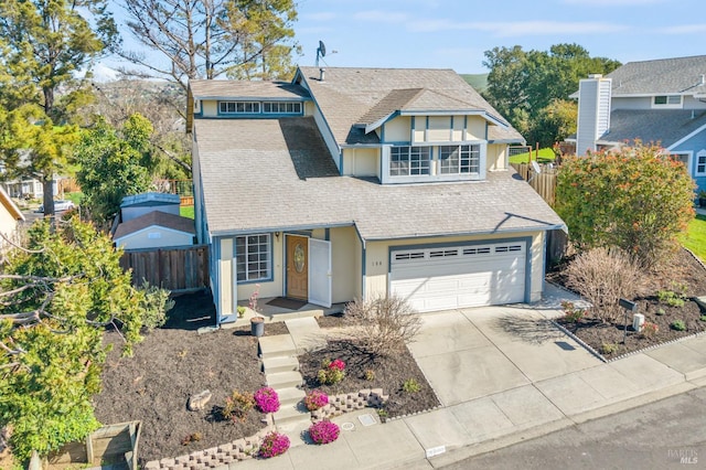 view of front of property featuring fence, driveway, an attached garage, and stucco siding