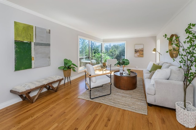 living area with light wood finished floors, baseboards, and crown molding