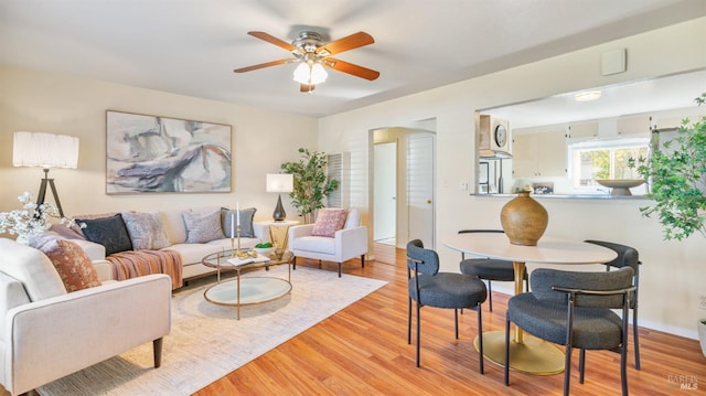 living room featuring a ceiling fan and light wood-style flooring