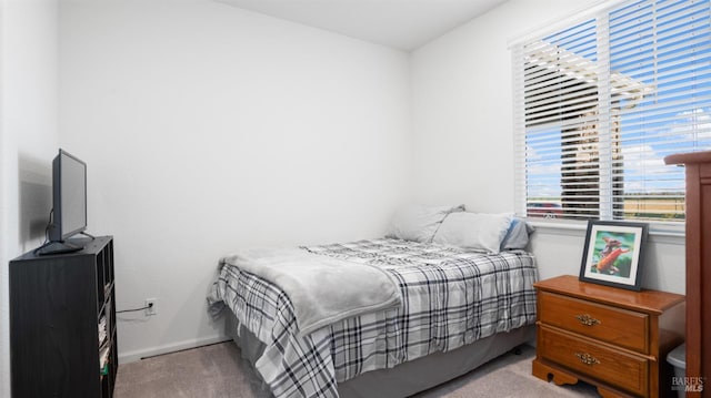 bedroom with light colored carpet and baseboards