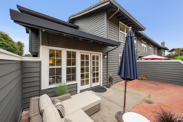 rear view of property with a patio, an outdoor living space, and a jacuzzi