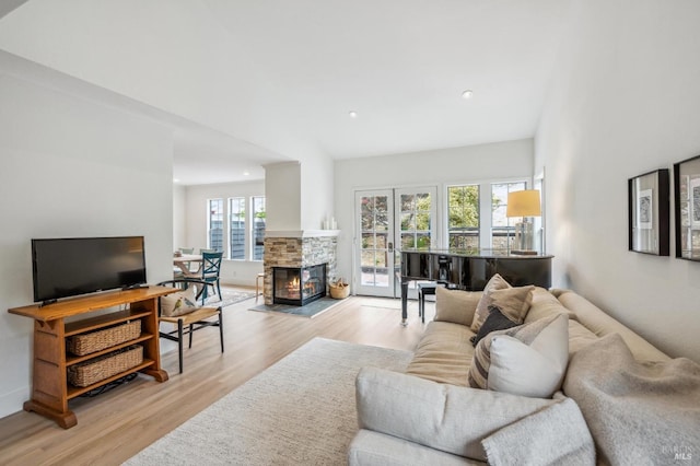 living room featuring recessed lighting, a fireplace, and light wood finished floors