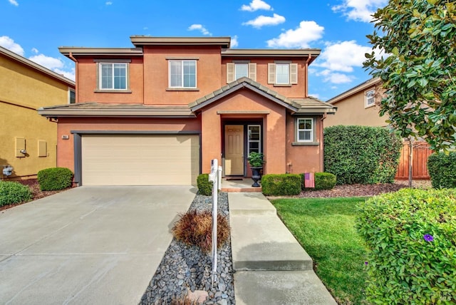 traditional-style home featuring driveway, an attached garage, fence, and stucco siding