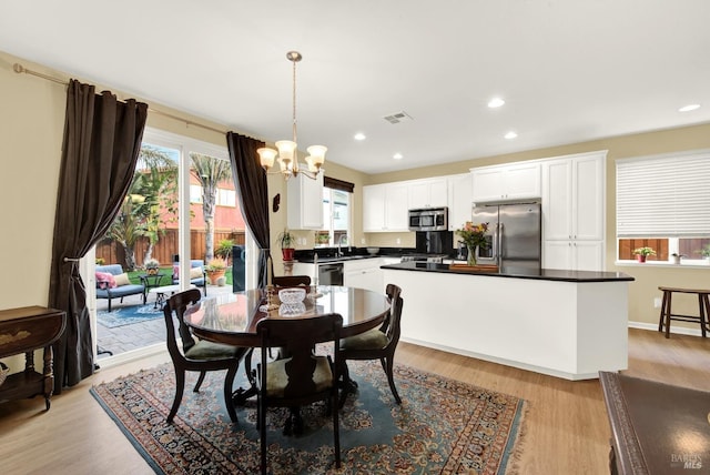 dining space featuring light wood finished floors, recessed lighting, visible vents, and a notable chandelier