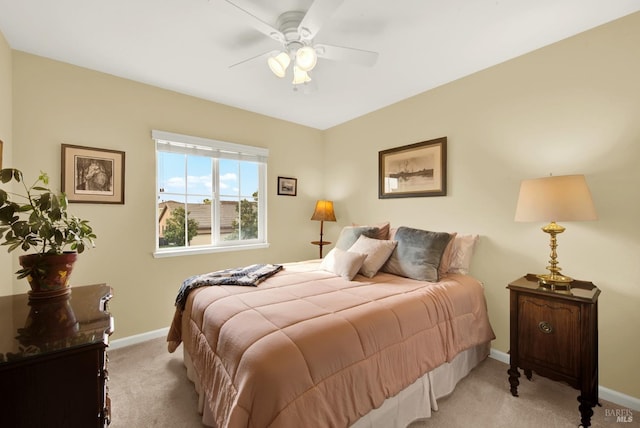 bedroom with light carpet, ceiling fan, and baseboards