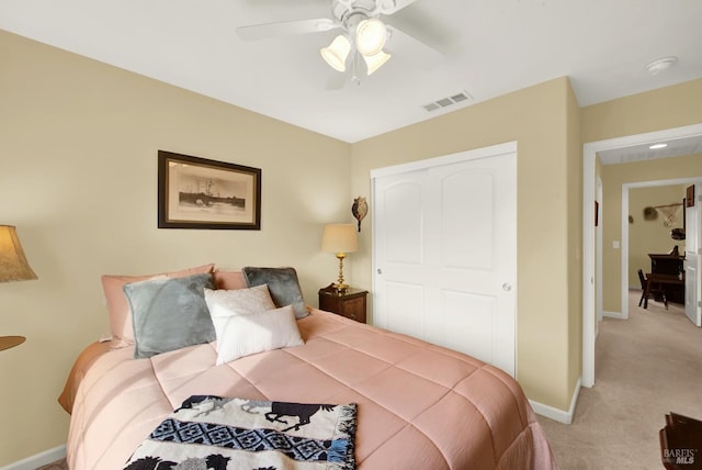 bedroom with light colored carpet, a ceiling fan, baseboards, visible vents, and a closet