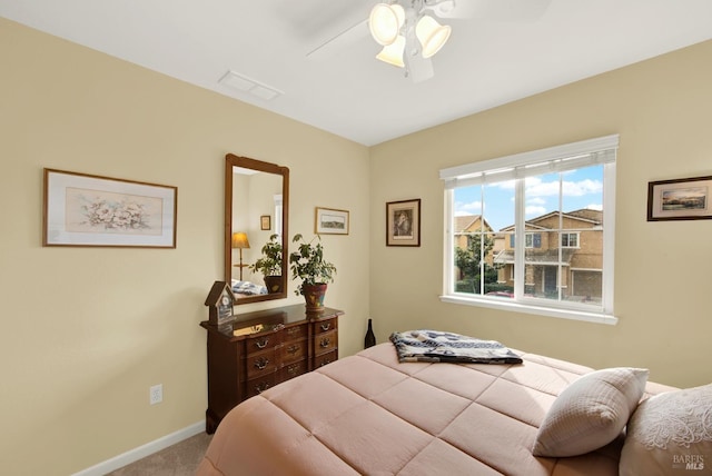 bedroom with a ceiling fan, light carpet, visible vents, and baseboards