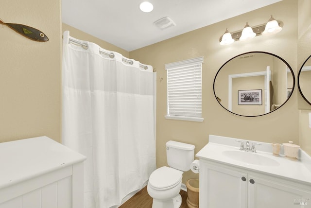 full bath with toilet, vanity, and visible vents