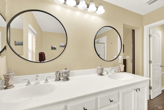 bathroom with double vanity, a sink, and visible vents