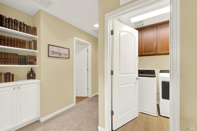 hall with light carpet, independent washer and dryer, visible vents, and baseboards