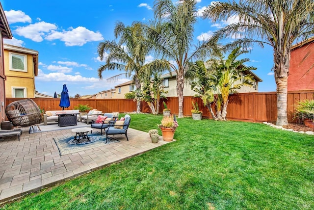 view of yard with a patio, a fenced backyard, and an outdoor living space with a fire pit