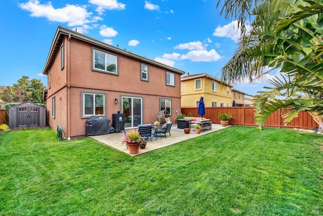 rear view of house featuring a fire pit, a fenced backyard, a storage unit, a patio area, and stucco siding