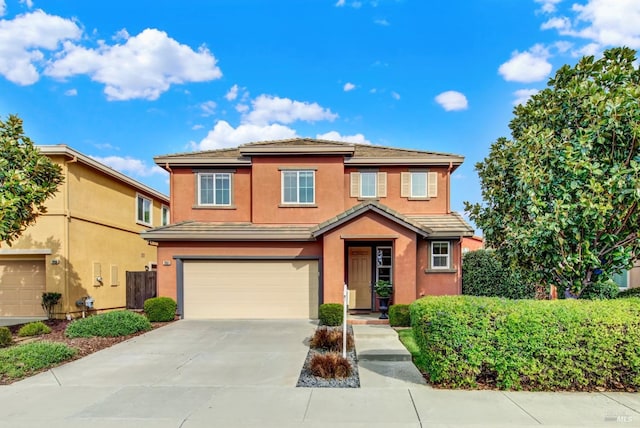 view of front of property with driveway, an attached garage, a tile roof, and stucco siding