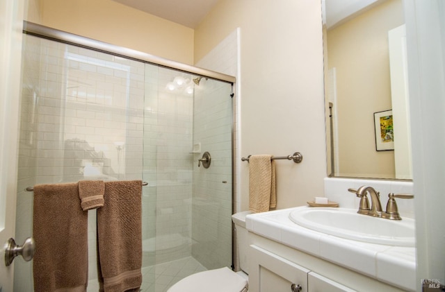 bathroom with vanity, toilet, and a shower stall