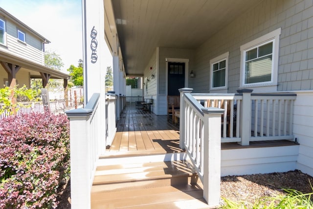 wooden terrace featuring fence and covered porch