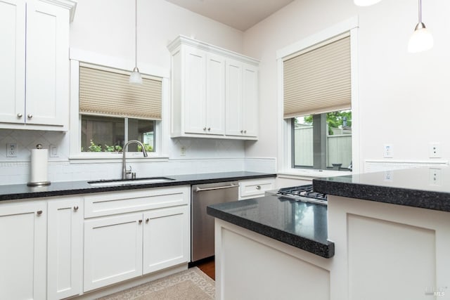 kitchen featuring hanging light fixtures, backsplash, dishwasher, and a sink