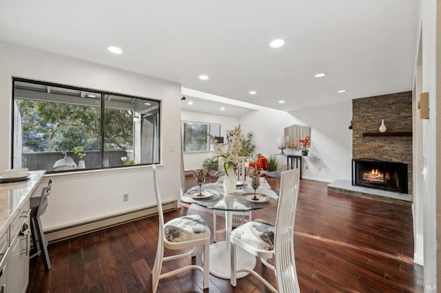 dining area featuring dark wood-style floors, a baseboard radiator, a fireplace, and recessed lighting