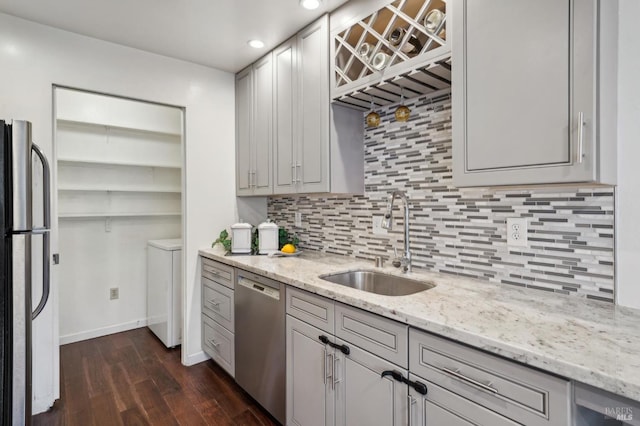 kitchen with light stone counters, dark wood-style flooring, a sink, appliances with stainless steel finishes, and open shelves