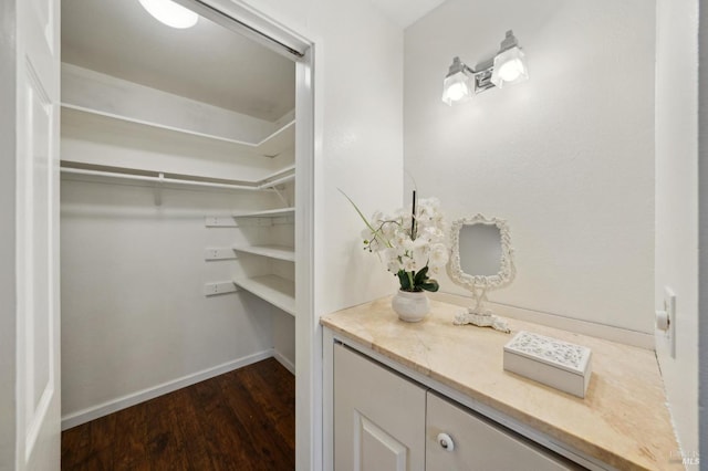 walk in closet with dark wood-type flooring