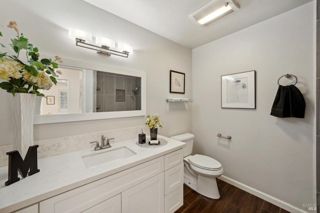 bathroom featuring baseboards, vanity, toilet, and wood finished floors