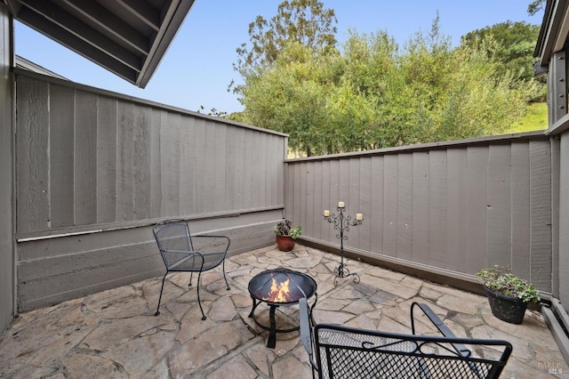 view of patio / terrace featuring an outdoor fire pit and a fenced backyard