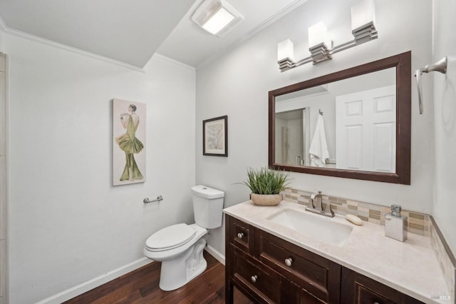 bathroom featuring ornamental molding, backsplash, vanity, and wood finished floors