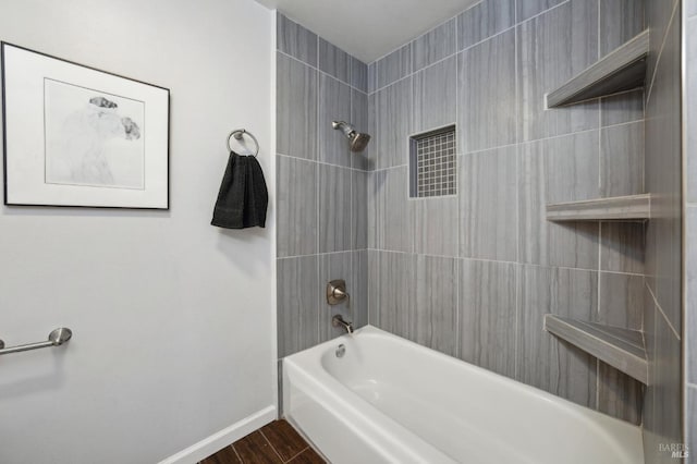 bathroom featuring baseboards, wood finished floors, and shower / bathtub combination