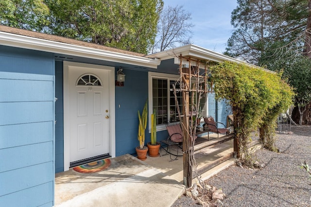 view of exterior entry with a patio area